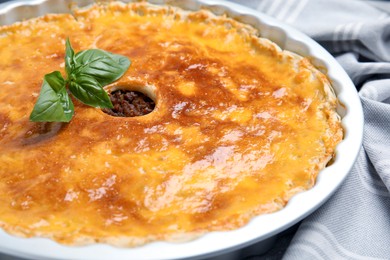 Delicious pie with minced meat on light grey towel, closeup
