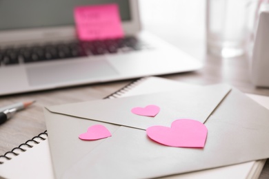 Photo of Envelope and hearts at workplace, closeup with space for text. Valentine's Day celebration