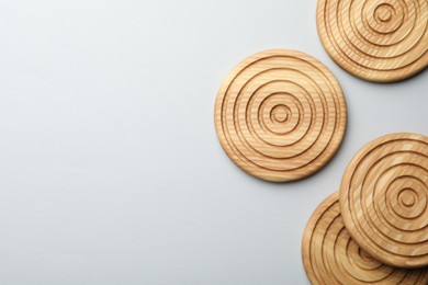 Photo of Stylish wooden cup coasters on light background, flat lay. Space for text