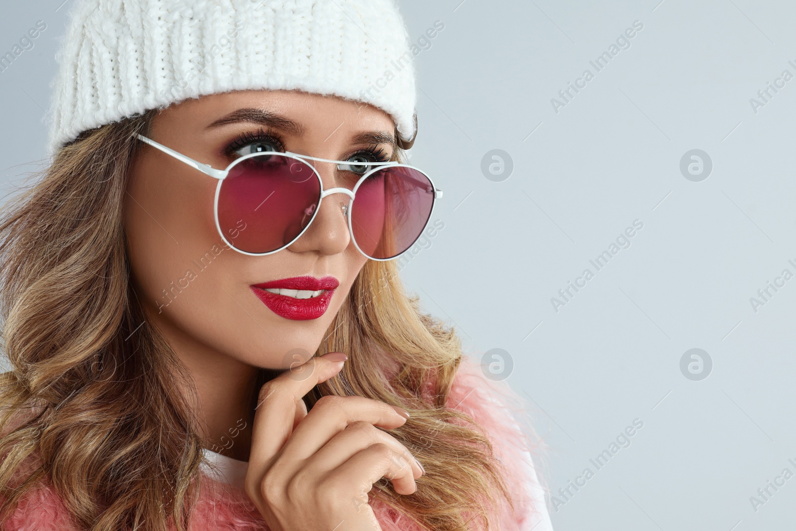 Photo of Young woman wearing stylish sunglasses on light grey background. Space for text