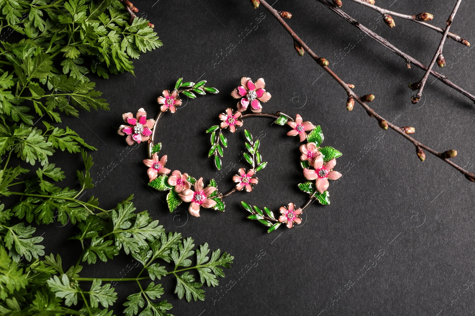 Photo of Composition with beautiful earrings on black background. Luxury jewelry