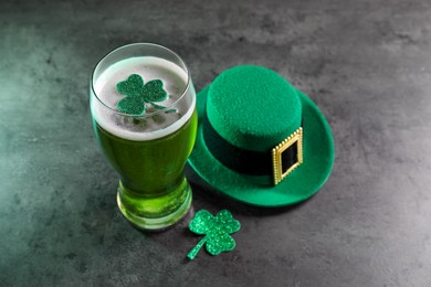 St. Patrick's day celebration. Green beer, leprechaun hat and decorative clover leaves on grey table