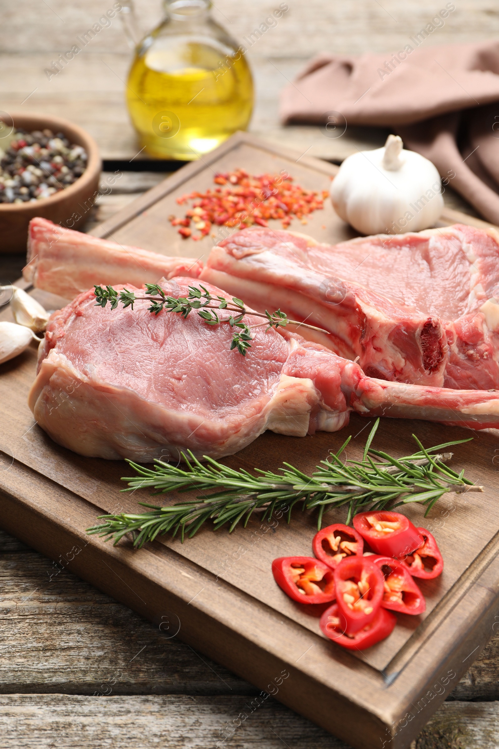 Photo of Fresh tomahawk beef cuts and spices on wooden table