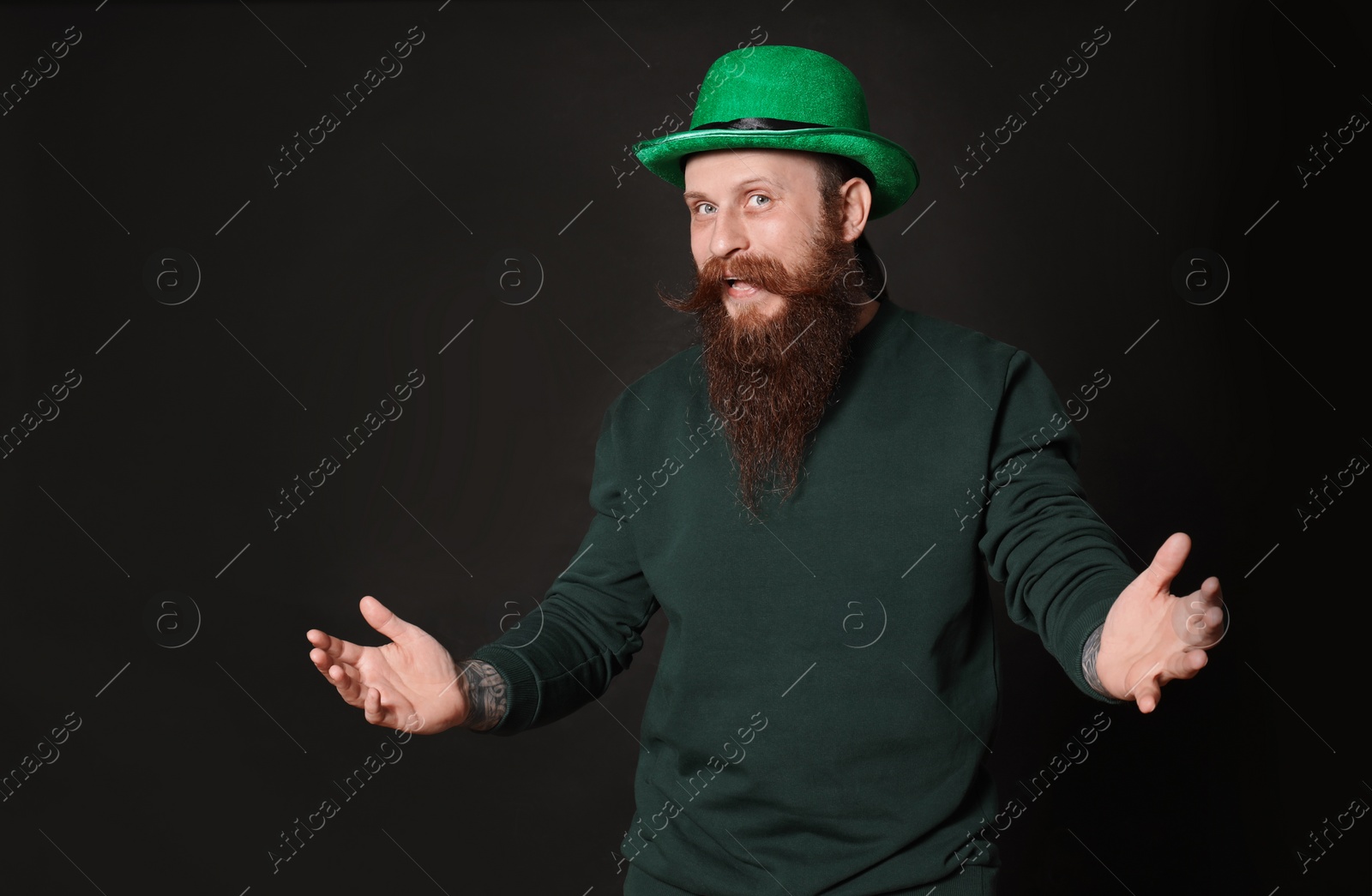 Photo of Bearded man in green hat on black background. St. Patrick's Day celebration