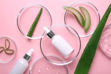 Photo of Flat lay composition with aloe vera leaves and cosmetic products on pink background