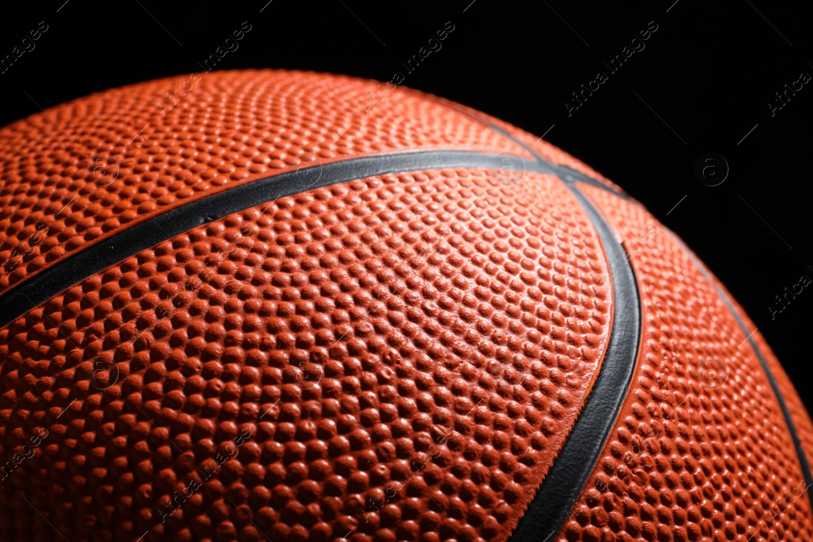 Photo of Orange basketball ball on black background, closeup