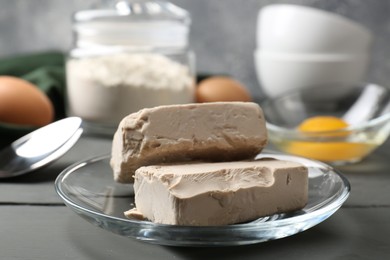 Compressed yeast, eggs and flour on grey table