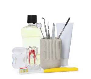 Photo of Tooth model, oral hygiene products and dentist tools on white background