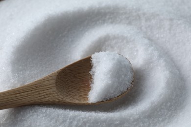 Wooden spoon on white sea salt, closeup