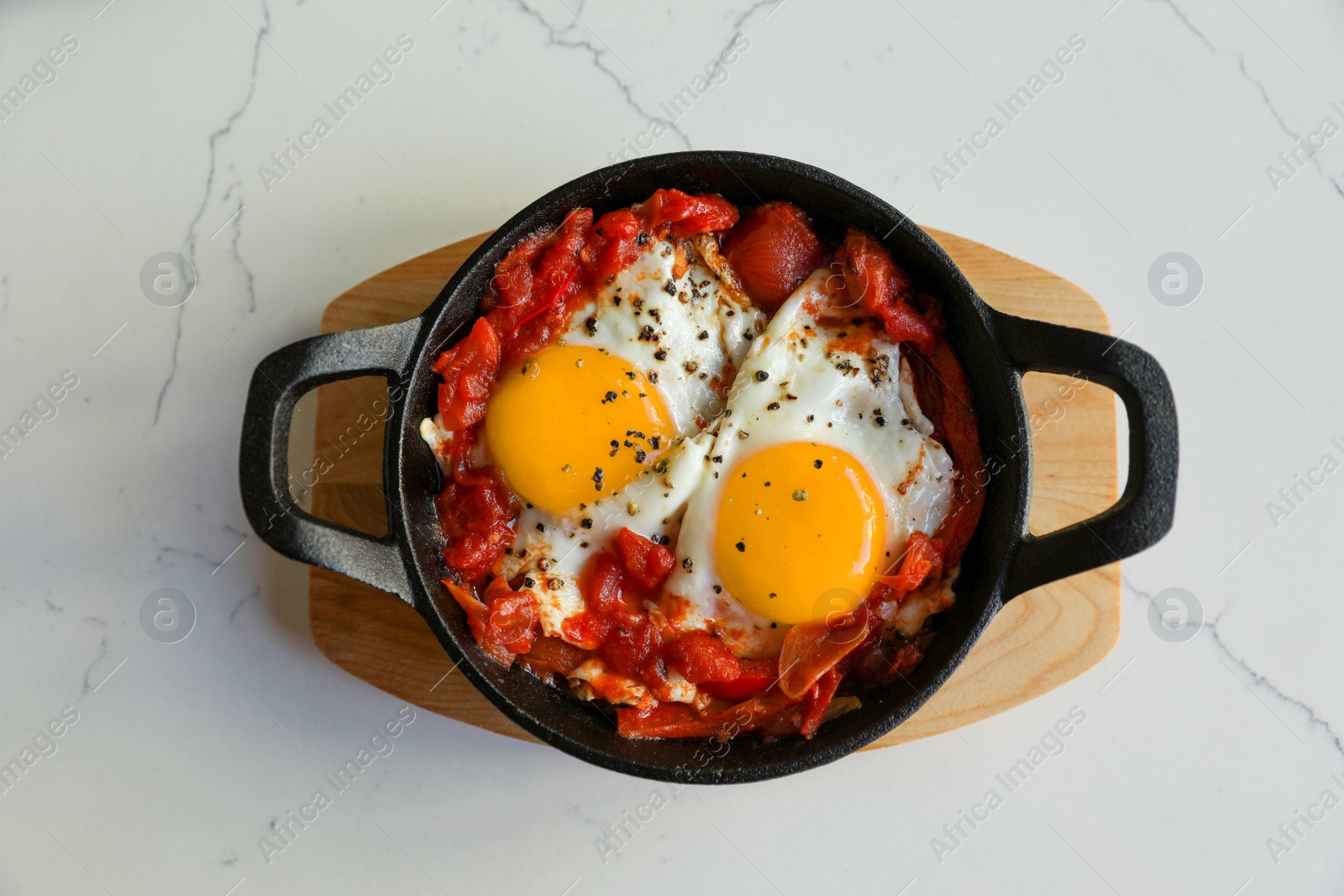 Photo of Tasty Shakshouka served on white marble table, top view