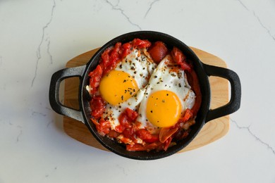 Tasty Shakshouka served on white marble table, top view