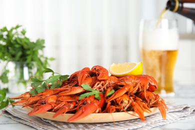 Photo of Delicious boiled crayfishes with parsley on white table