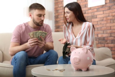 Unhappy young couple with money at home. Financial problems