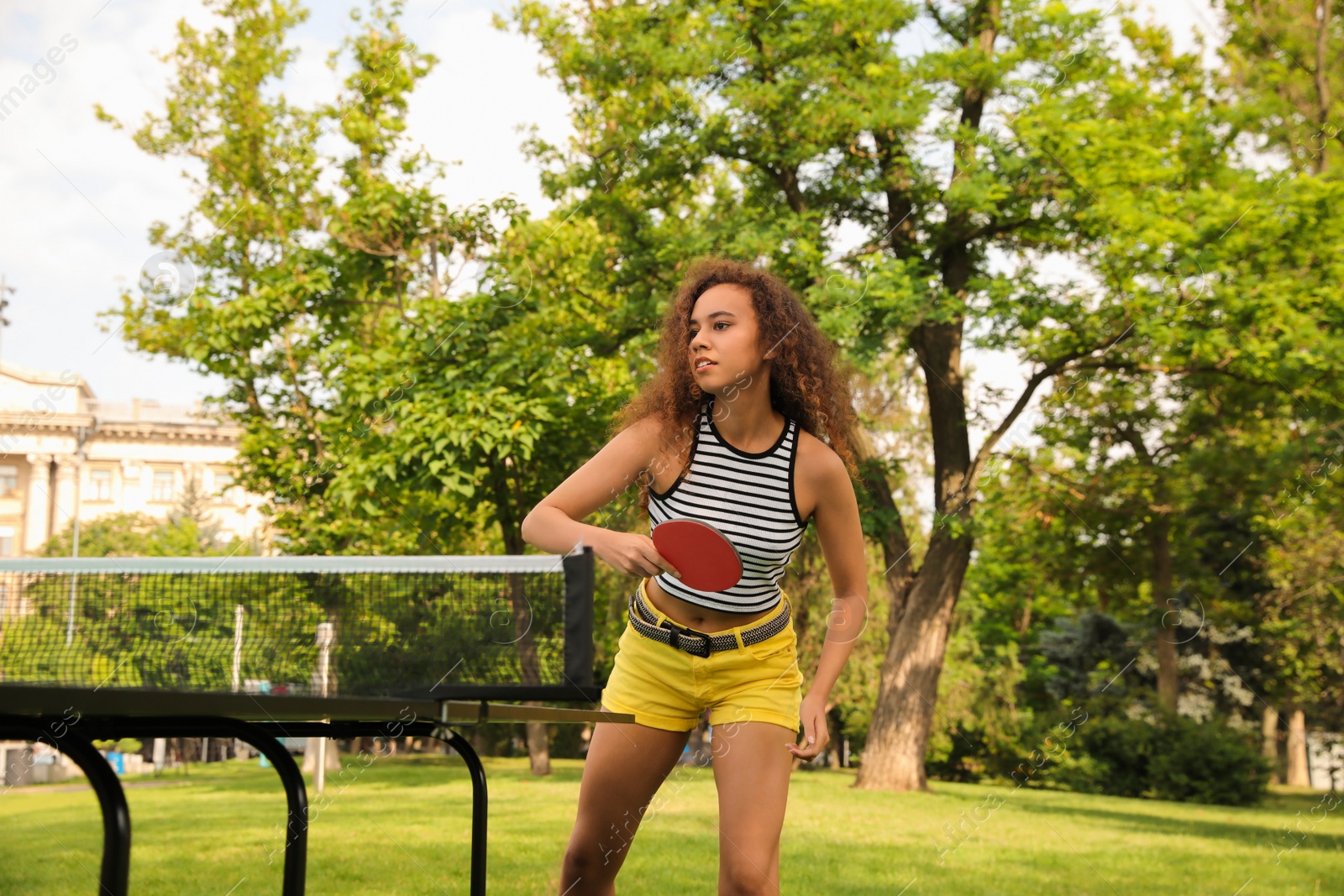 Photo of Young African-American woman playing ping pong outdoors