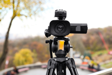 Video camera on tripod outdoors. Professional equipment