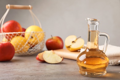 Photo of Composition with jug of apple vinegar on table. Space for text