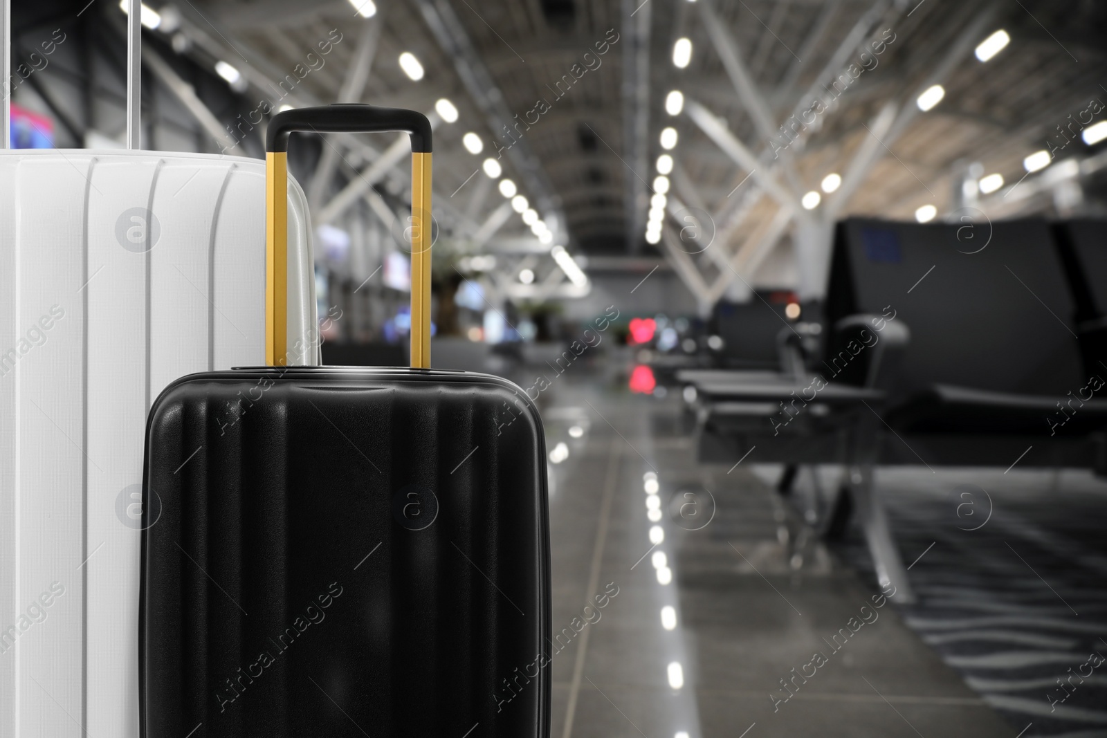 Image of Stylish suitcases in waiting area at airport terminal