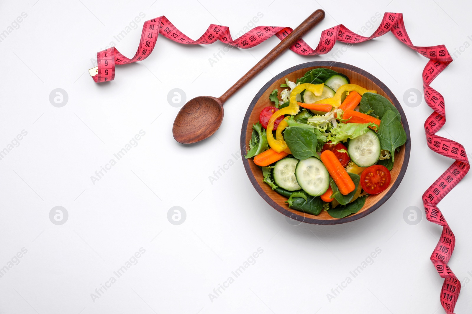 Photo of Measuring tape, salad and spoon on white background, flat lay. Space for text