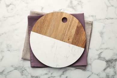 Photo of Serving board and napkins on white marble table, top view. Space for text