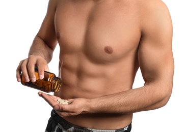 Photo of Athletic man with bottle of pills on white background, closeup. Doping concept