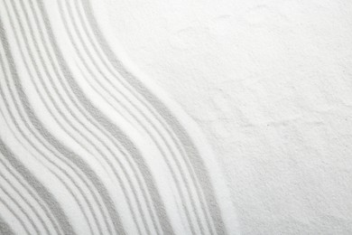 Photo of Zen rock garden. Wave pattern on white sand, top view