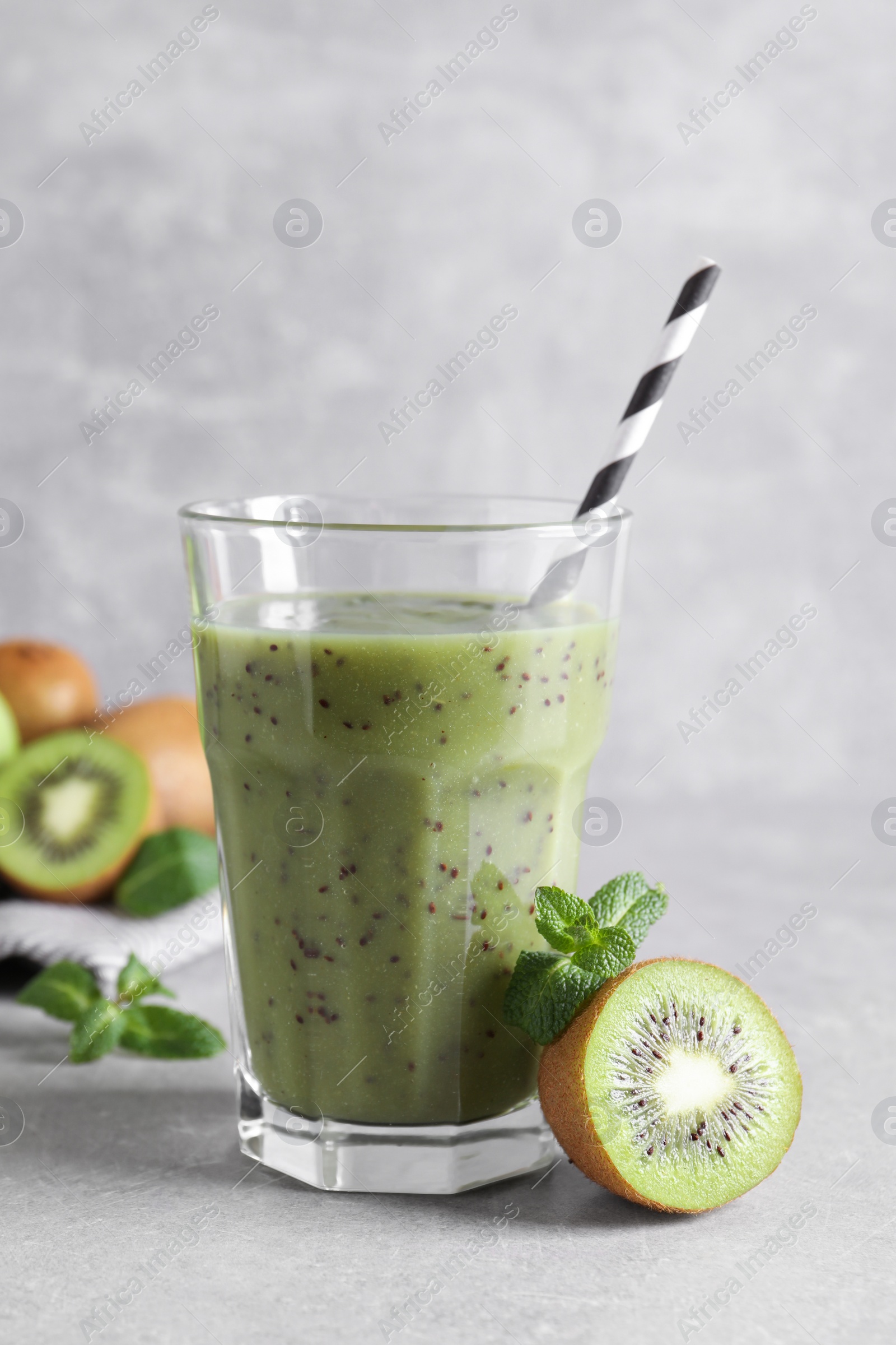 Photo of Delicious kiwi smoothie and fresh fruits on light table