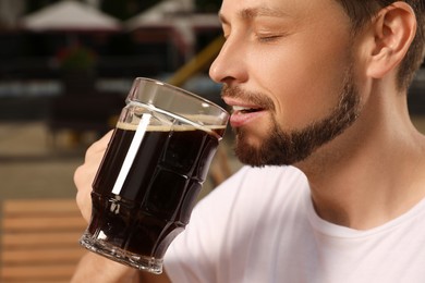 Photo of Man drinking dark beer in cafe, closeup