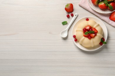 Photo of Delicious semolina pudding with berries on white wooden table, flat lay. Space for text