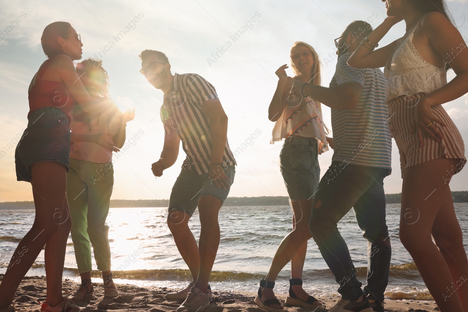 Photo of Group of friends having fun near river at summer party