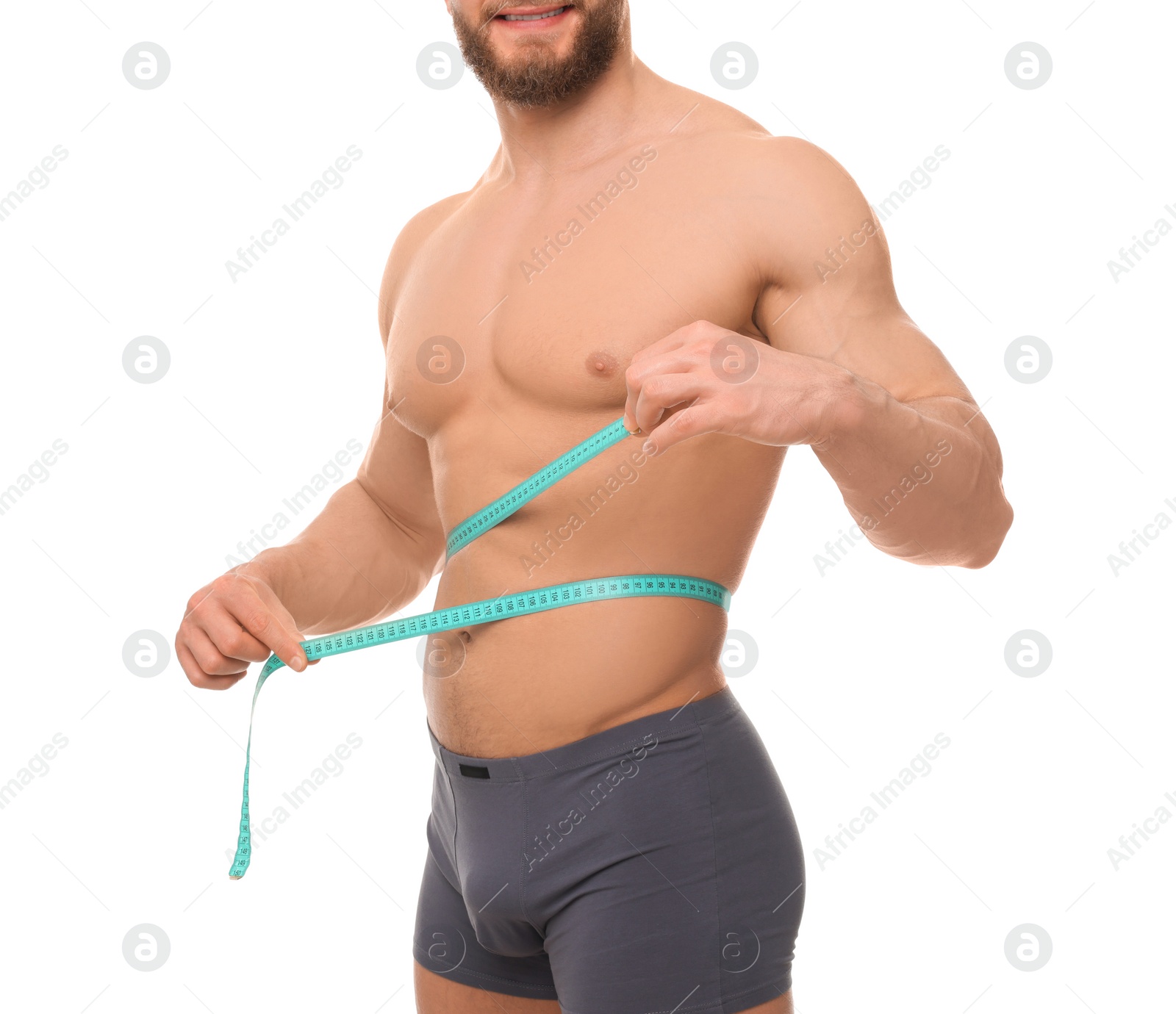 Photo of Athletic man measuring waist with tape on white background, closeup. Weight loss concept