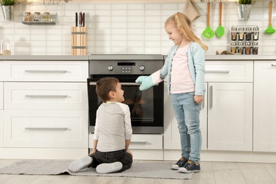 Photo of Little kids baking buns in oven at home