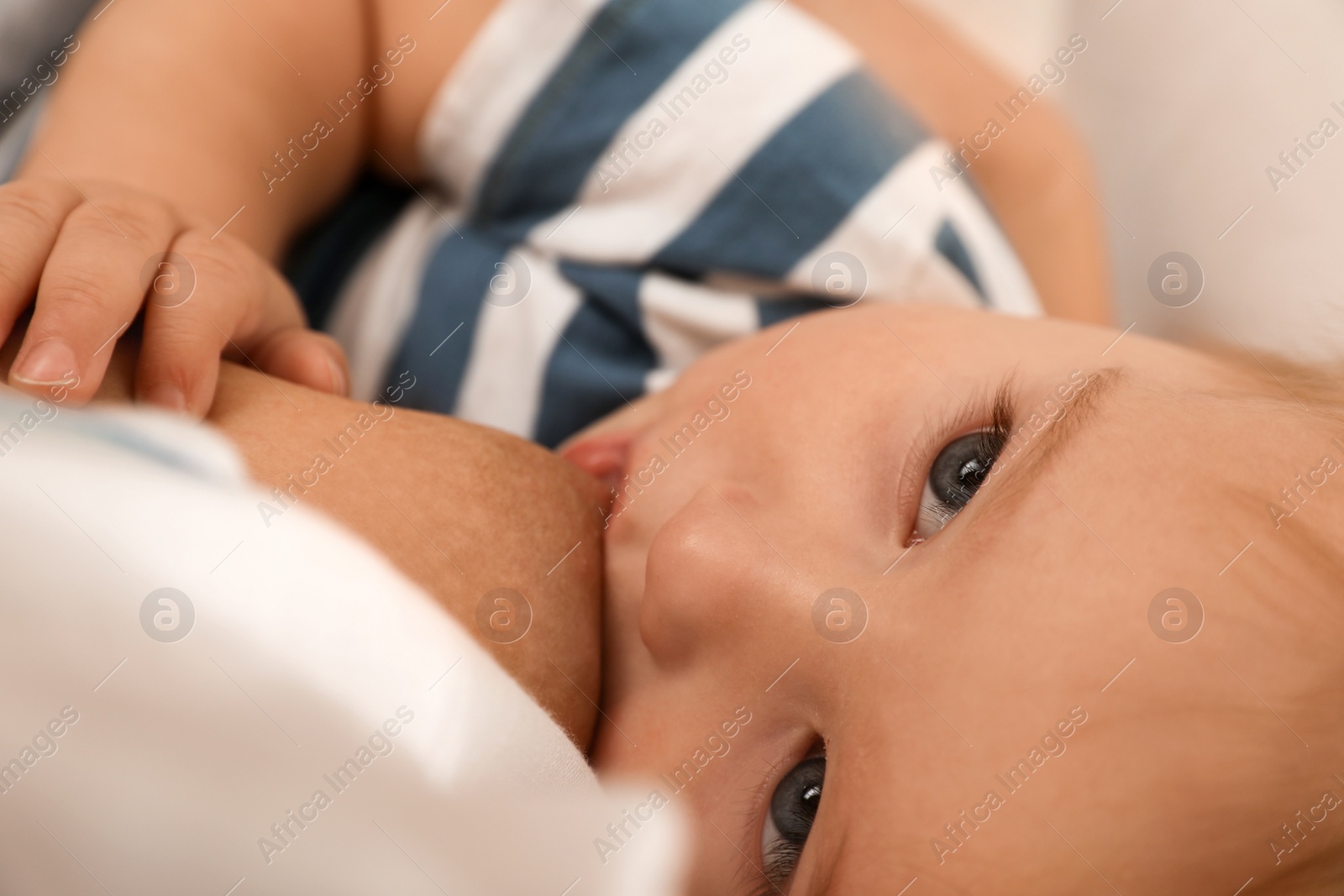 Photo of Woman breastfeeding her little baby, closeup view