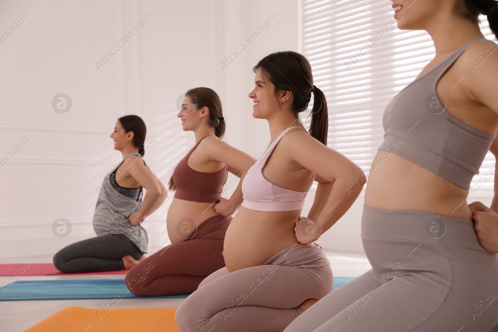 Photo of Group of pregnant women doing exercises in gym. Preparation for child birth