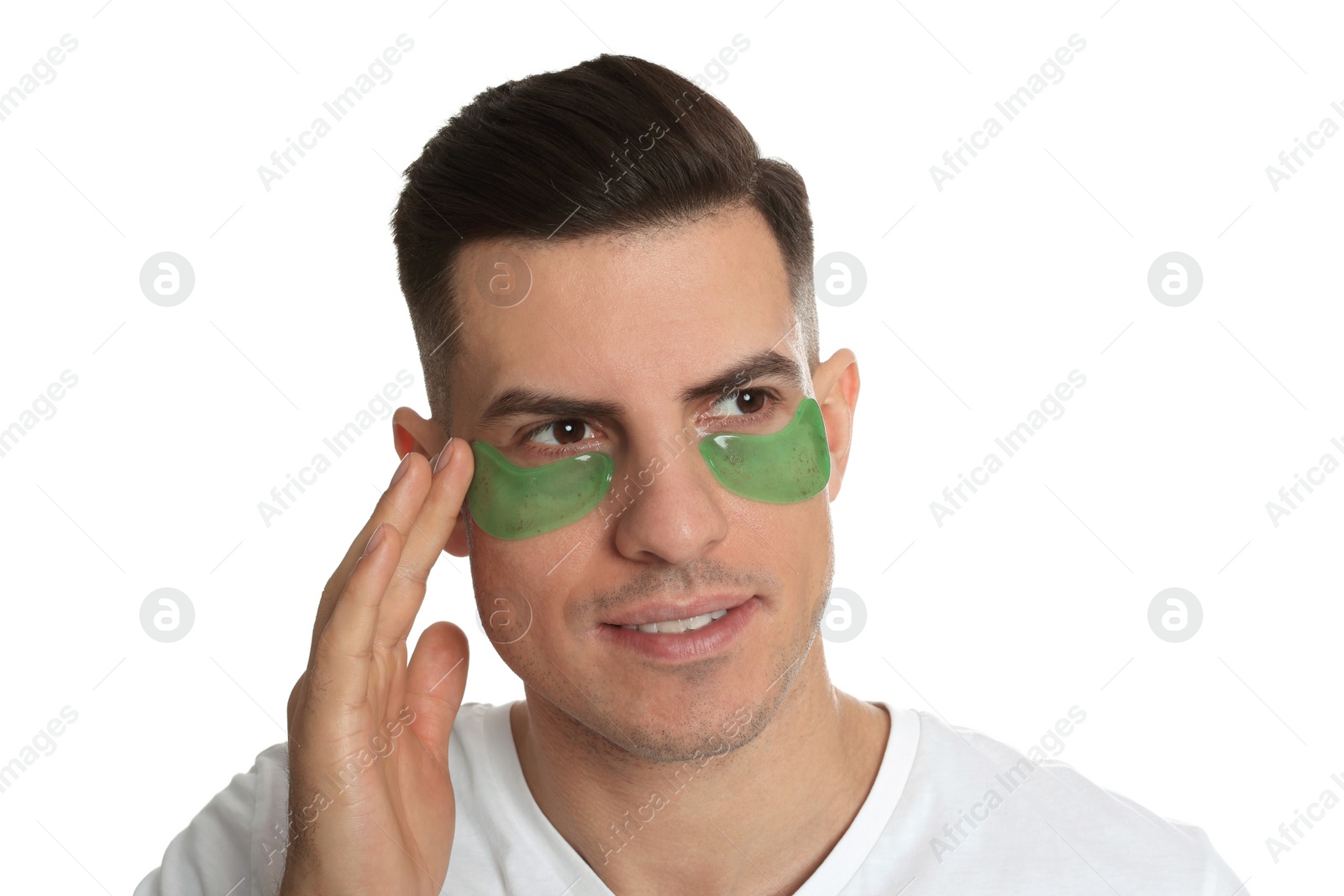 Photo of Man applying green under eye patch on white background