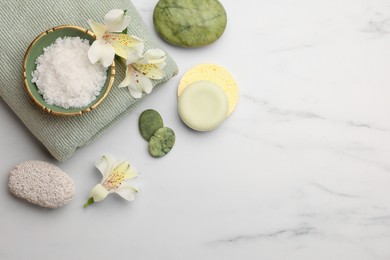 Photo of Flat lay composition with spa products and flowers on white marble table. Space for text