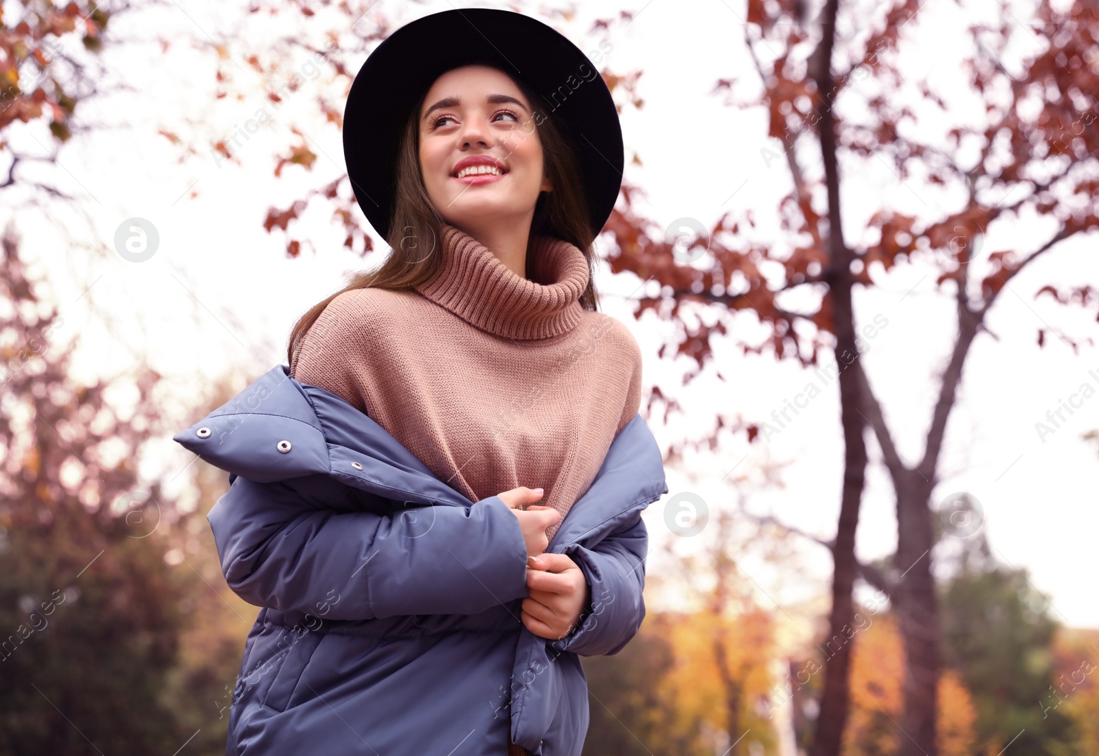 Photo of Young woman wearing stylish clothes in autumn park