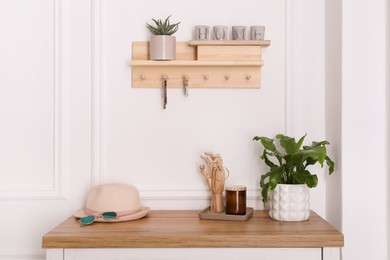 Photo of Wooden hanger for keys on white wall in hallway