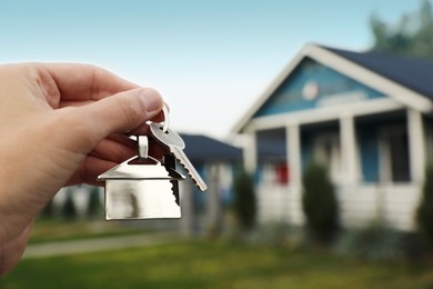 Woman holding house keys outdoors, closeup with space for text. Real estate agent