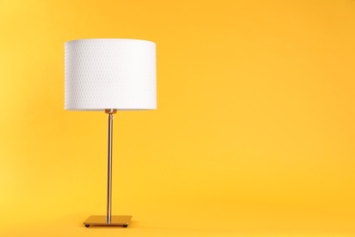 Stylish new night lamp on yellow background. Space for text