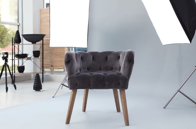 Photo of Interior of modern photo studio with armchair and professional equipment