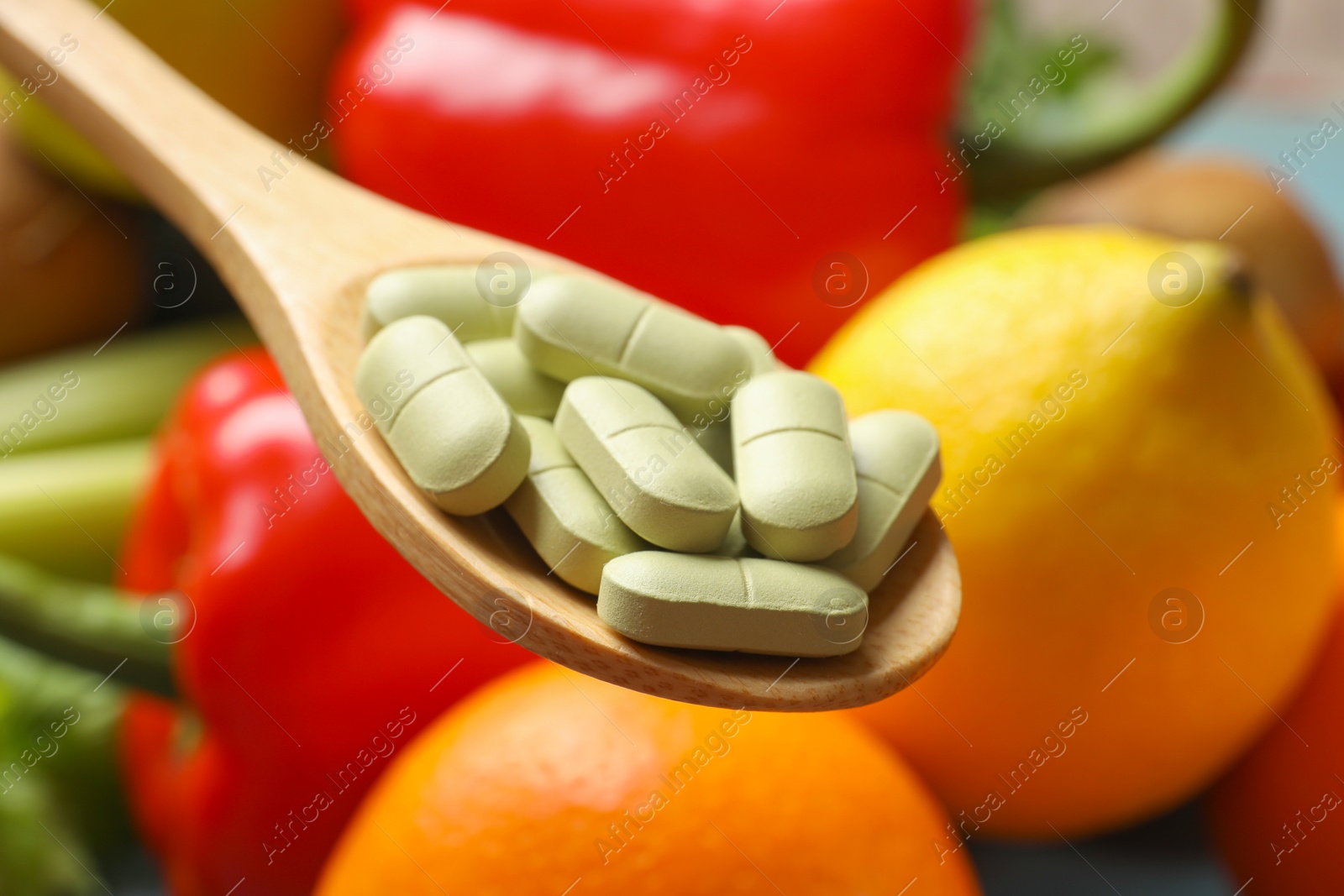 Photo of Dietary supplements. Spoon with pills over food products, closeup