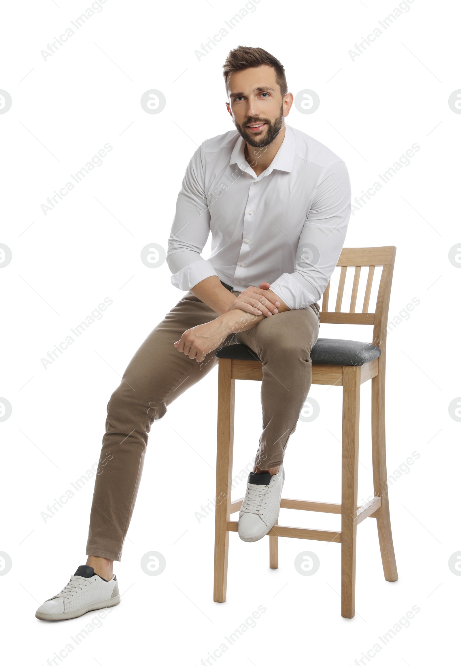 Photo of Handsome man sitting on stool against white background