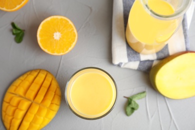 Fresh mango drink and tropical fruits on grey table, top view