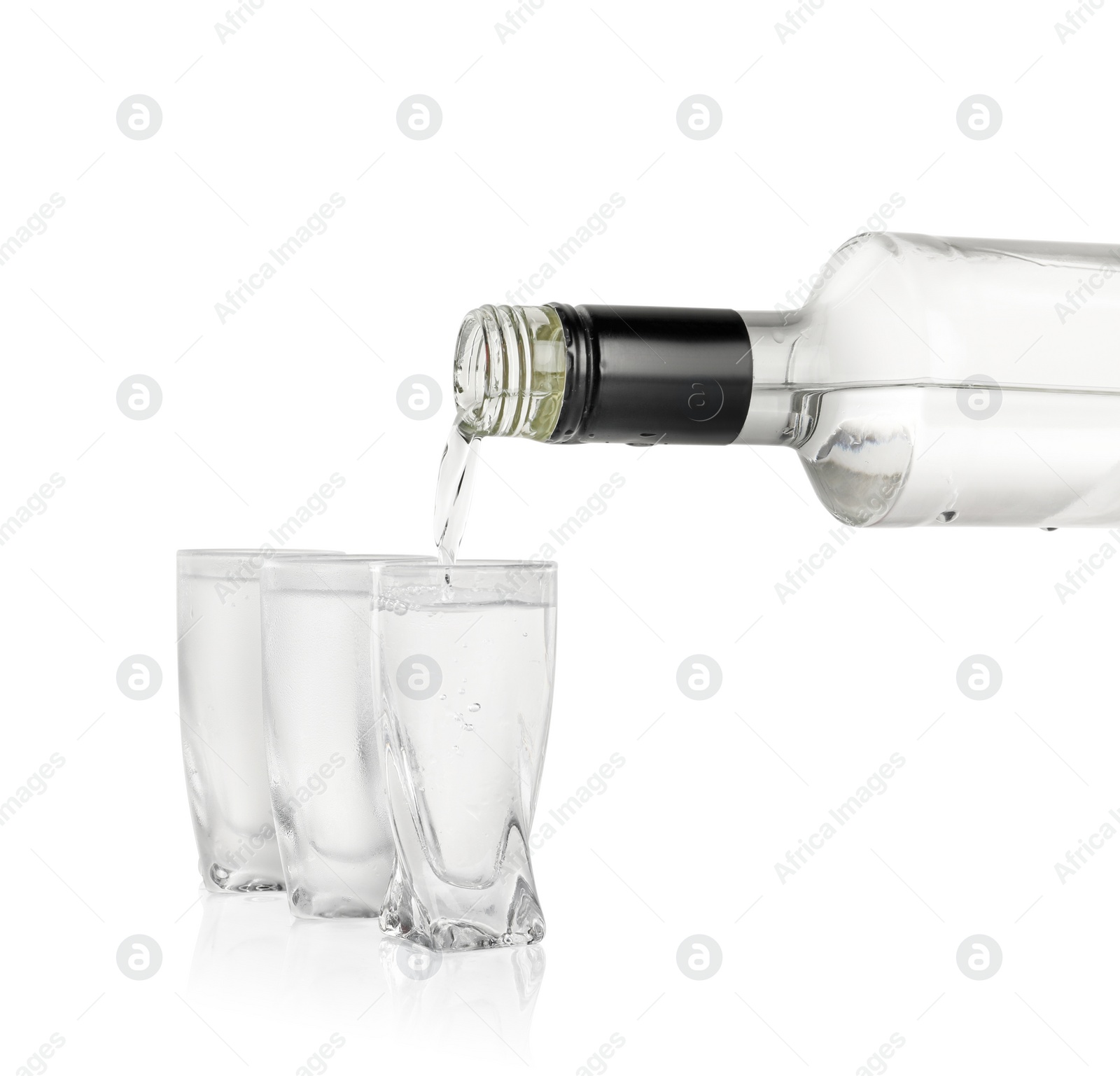 Photo of Pouring vodka from bottle in glass on white background