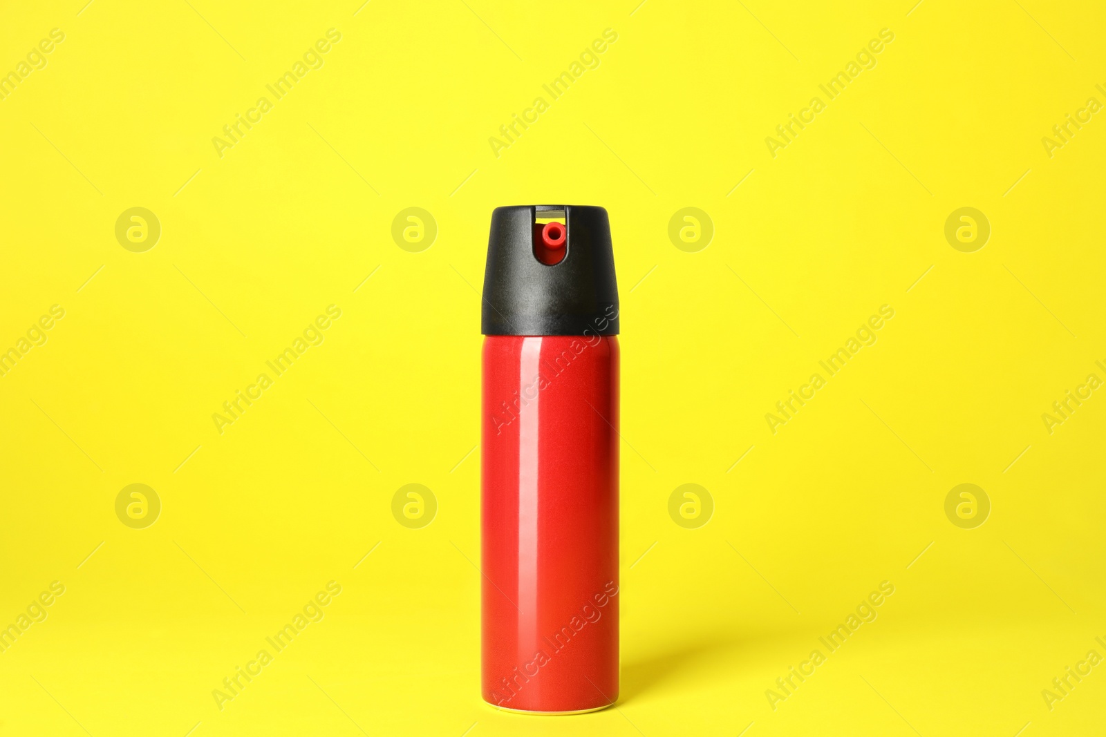 Photo of Bottle of gas pepper spray on yellow background