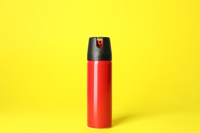 Photo of Bottle of gas pepper spray on yellow background