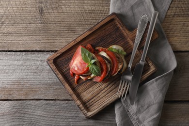 Delicious ratatouille served with basil on wooden table, flat lay. Space for text