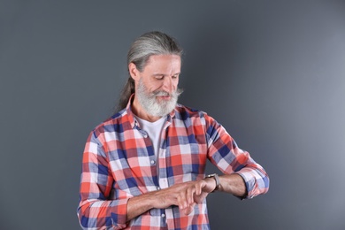 Photo of Handsome bearded mature man on color background