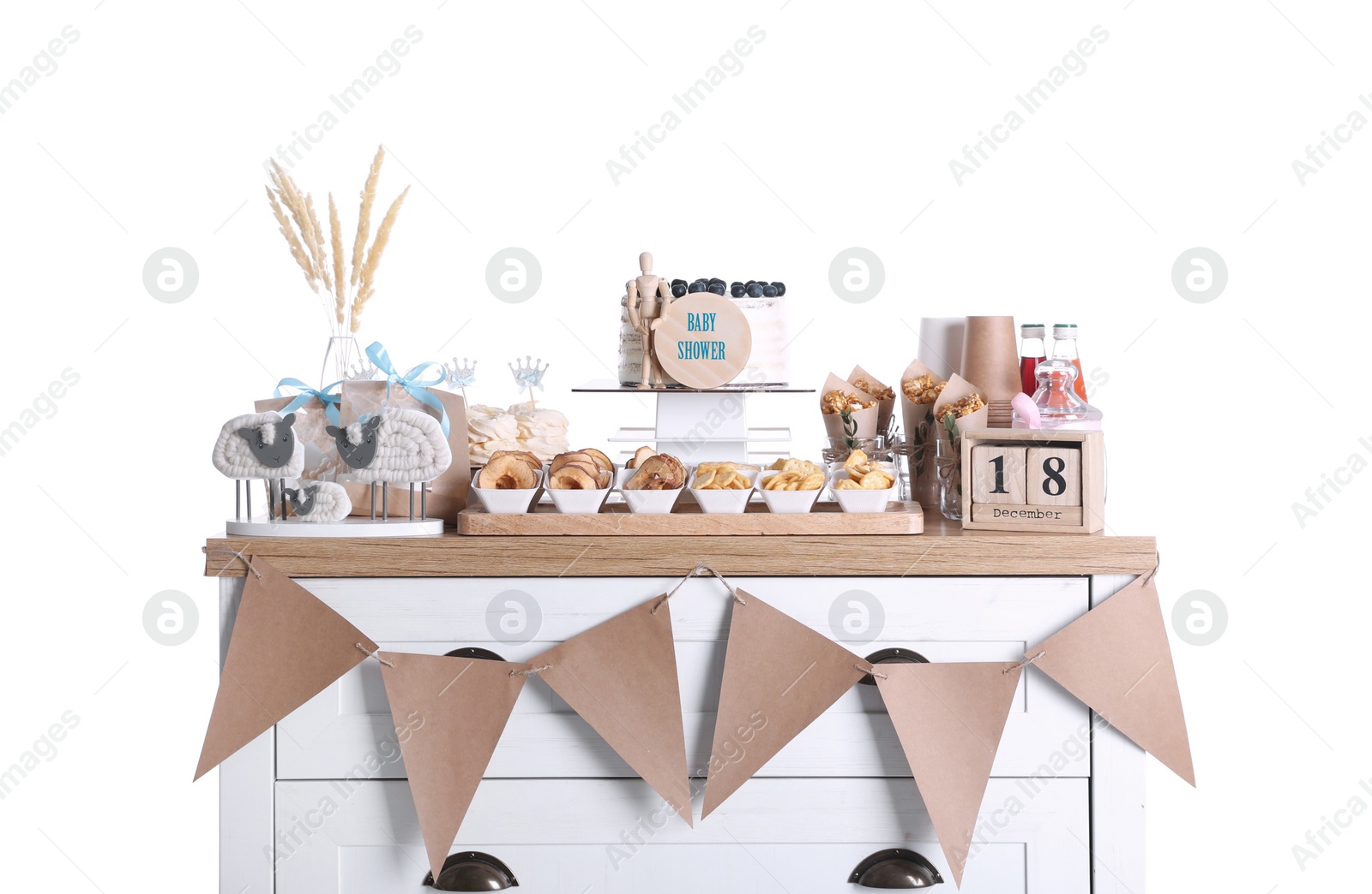 Photo of Baby shower party. Different delicious treats on chest of drawers and decor against white background