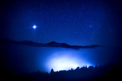 Image of Sky with twinkling stars over mountains at night